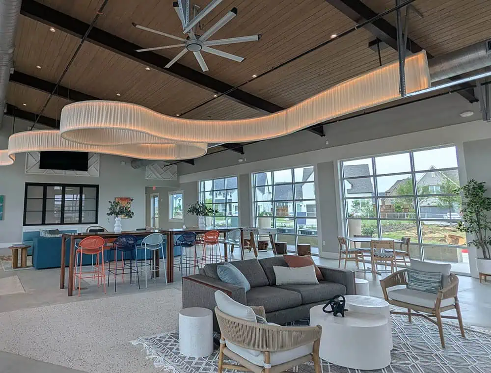 Bright, modern Windsong Ranch amenity center interior with high ceilings, lounge seating, and large windows