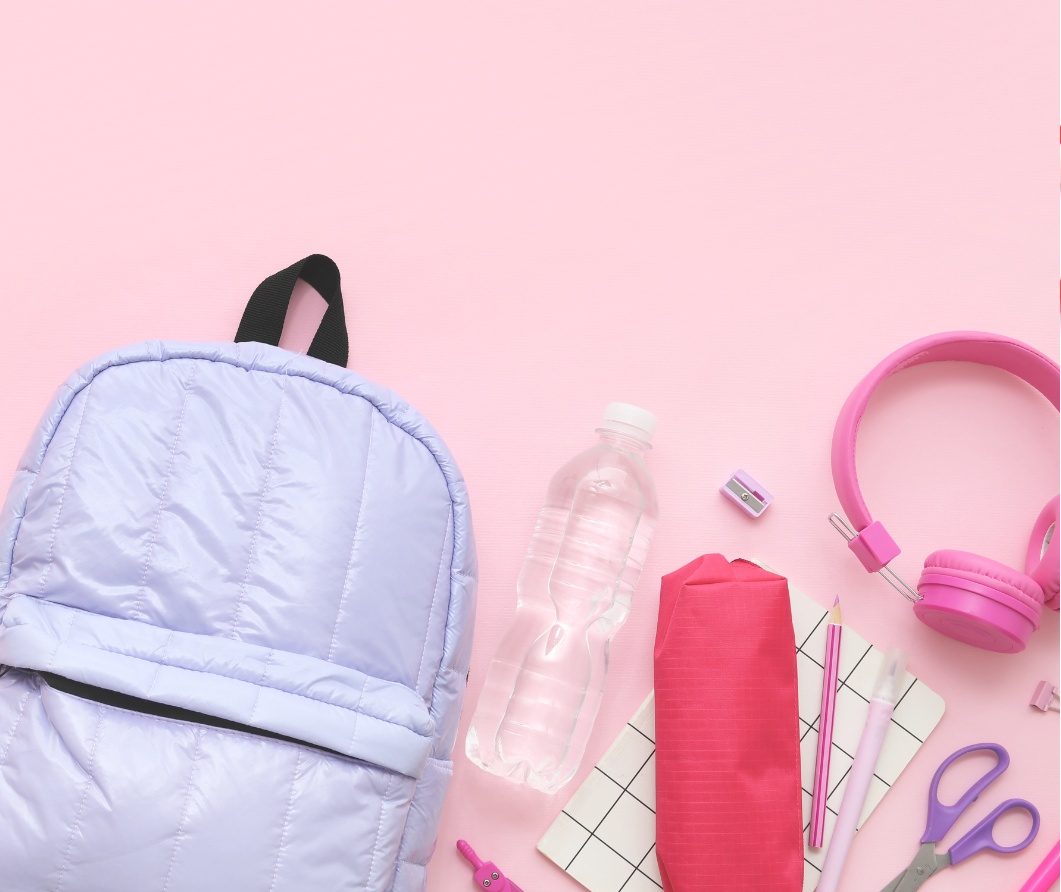 School backpack and supplies on a pink background
